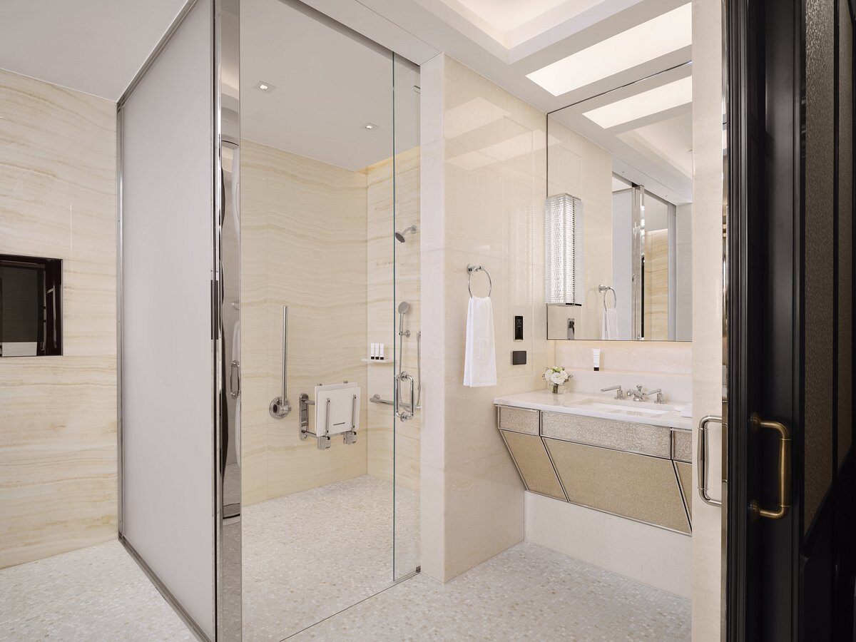 Modern, clean shower and vanity with minimalistic stainless steel accessible bathroom equipment and accessories 