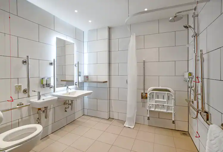 Stylish, clean and clinical toilet, basin and shower with accessible bathroom equipment