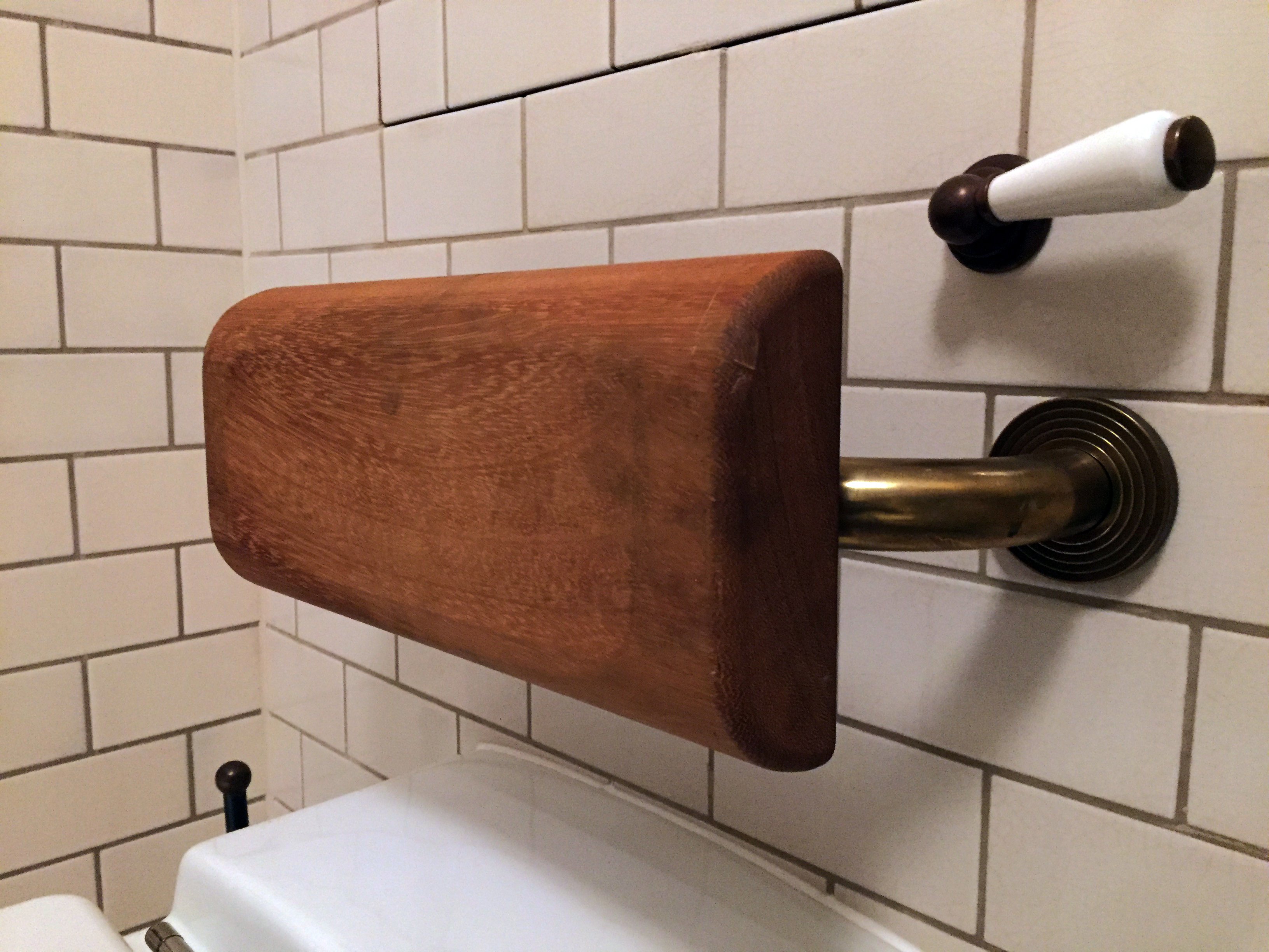 A close up of a Solid Brass Concealed Flange Back Rest Rail And Pad in Brown Suede